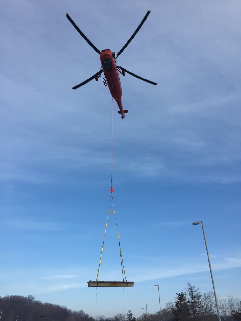 Helicopter lifting a concrete deck panel
